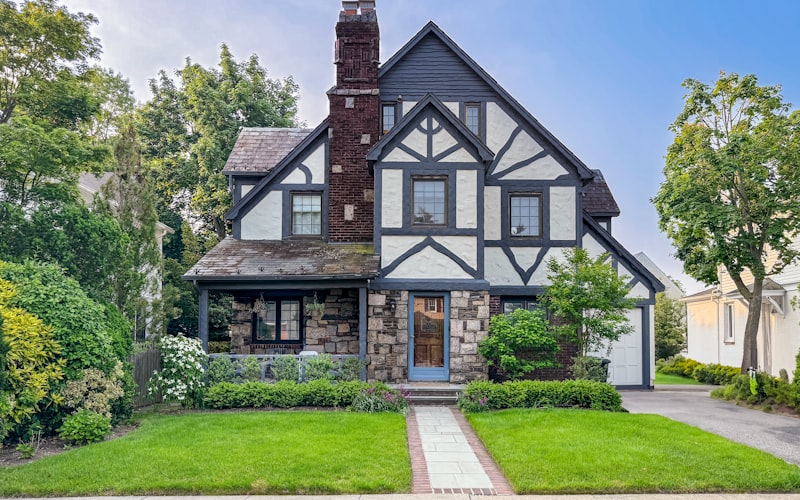 Beautiful Tudor-style home with manicured lawn and landscaping
